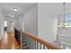 Upstairs hallway with wood floors and access to bedrooms at 629 Peach Orchard Pl, Cary, NC 27519