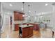 Open kitchen with granite countertops, a central island, stainless steel appliances, and hardwood floors at 629 Peach Orchard Pl, Cary, NC 27519