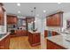 Kitchen featuring stainless appliances, wooden cabinetry, hardwood floors and granite counters at 629 Peach Orchard Pl, Cary, NC 27519