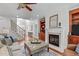 Bright living room with fireplace, hardwood floors, built-in shelving, and access to the foyer at 629 Peach Orchard Pl, Cary, NC 27519
