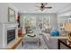Spacious living room with a fireplace, ceiling fan, large windows, and comfortable seating at 629 Peach Orchard Pl, Cary, NC 27519