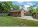Well maintained backyard showcasing manicured grass, stone patio, and mature trees at 704 W Front St, Burlington, NC 27215