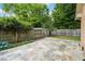 Spacious backyard featuring a large stone patio, well-manicured lawn, and mature trees at 704 W Front St, Burlington, NC 27215