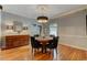 A dining room is shown with hardwood floors and modern chandelier at 704 W Front St, Burlington, NC 27215