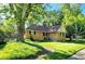Well-maintained brick home featuring green lawn and mature trees at 704 W Front St, Burlington, NC 27215