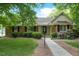 Charming brick home featuring manicured landscaping and a welcoming walkway to the front door at 704 W Front St, Burlington, NC 27215