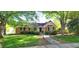 Charming brick home with black shutters, a manicured lawn, and mature shade trees at 704 W Front St, Burlington, NC 27215