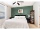 Green-walled bedroom featuring a ceiling fan, tray ceiling, and display cabinet, creating an elegant and comfortable space at 7328 Caversham Way, Raleigh, NC 27617
