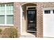 Inviting front entrance featuring a brick facade, elegant door, and manicured shrubbery at 7328 Caversham Way, Raleigh, NC 27617