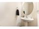 Cozy powder room featuring pedestal sink, round mirror, and decorative towel rack at 7328 Caversham Way, Raleigh, NC 27617