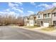 Multiple townhouses are pictured along a street with bare trees and a bright blue sky at 7328 Caversham Way, Raleigh, NC 27617