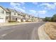 View of several townhomes with attached garages and neatly kept lawns along a quiet street at 7328 Caversham Way, Raleigh, NC 27617