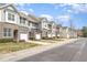 Street view of multi-colored townhouses showcasing manicured lawns and attached garages at 7328 Caversham Way, Raleigh, NC 27617