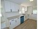 Bright kitchen features white cabinets, granite countertops, stainless steel sink and a blue dishwasher at 7702 Nc Highway 581, Kenly, NC 27542