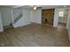 Spacious open-concept area with stairs, brick accent wall, and luxury vinyl plank flooring at 7702 Nc Highway 581, Kenly, NC 27542