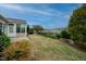 Expansive backyard with lush landscaping, manicured shrubs, and a view of the sunroom from the house at 833 Gaston Manor Dr, Durham, NC 27703