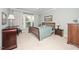 Bright bedroom featuring a wood bed frame, large windows, and neutral carpet flooring at 833 Gaston Manor Dr, Durham, NC 27703