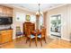 Cozy dining area featuring hardwood floors, classic furnishings, and natural light from the windows and sunroom at 833 Gaston Manor Dr, Durham, NC 27703