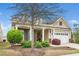 Charming home exterior featuring a covered porch, manicured landscaping, and a two-car garage at 833 Gaston Manor Dr, Durham, NC 27703