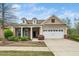 Charming single-Gathering home featuring a two-car garage, dormer windows, and manicured landscaping at 833 Gaston Manor Dr, Durham, NC 27703
