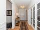 Bright hallway featuring hardwood floors, white trim, elegant lighting, console table and a view of the office at 833 Gaston Manor Dr, Durham, NC 27703