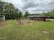 A backyard with a view of the house, and storage shed, surrounded by trees and a barbed wire fence at 8535 Us-301 S Hwy, Four Oaks, NC 27524