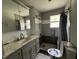 Bathroom with grey tiled shower, granite vanity, and brushed nickel fixtures at 8535 Us-301 S Hwy, Four Oaks, NC 27524