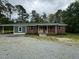 Charming brick home with a covered porch and ample parking on a gravel driveway at 8535 Us-301 S Hwy, Four Oaks, NC 27524