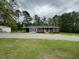 View of a charming brick house with a covered carport, complemented by a vast lawn at 8535 Us-301 S Hwy, Four Oaks, NC 27524