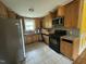 Well-lit kitchen with wood cabinets, modern appliances, and durable tiled flooring at 8535 Us-301 S Hwy, Four Oaks, NC 27524