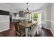 Bright dining room features a modern chandelier, beautiful floors, and open access to the kitchen and outdoor patio at 8700 Crowder Rd, Raleigh, NC 27603