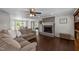 Bright living room features a brick fireplace, hardwood floors, and seamless access to the dining room at 8700 Crowder Rd, Raleigh, NC 27603