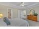 Large primary bedroom featuring a ceiling fan, ensuite access, a dresser and a large window at 9005 River Estates Dr, Knightdale, NC 27545