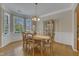 Dining room features a light-colored table, hardwood floors, large window, and a china cabinet at 9005 River Estates Dr, Knightdale, NC 27545