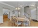 Dining room features a light-colored table, hardwood floors, and is open to kitchen and staircase at 9005 River Estates Dr, Knightdale, NC 27545
