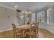 Bright dining room featuring an oval wood table, staircase, and bright bay windows offering a view of the yard at 9005 River Estates Dr, Knightdale, NC 27545
