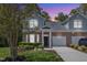 Charming two-story home with landscaped yard and mature trees at dusk at 9005 River Estates Dr, Knightdale, NC 27545