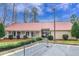 Community building featuring a covered front entrance, lush landscaping, parking and a red metal roof at 9005 River Estates Dr, Knightdale, NC 27545