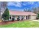 Charming, single-story home with a manicured lawn and garden, featuring a red roof and covered front porch at 9005 River Estates Dr, Knightdale, NC 27545