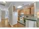 This kitchen features wood cabinets, hardwood floors, a breakfast bar, and white appliances at 9005 River Estates Dr, Knightdale, NC 27545