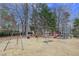 Community playground featuring swings and play equipment with wood chip ground cover and mature trees at 9005 River Estates Dr, Knightdale, NC 27545