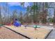 Community playground featuring colorful play equipment with wood chip ground cover and mature trees at 9005 River Estates Dr, Knightdale, NC 27545