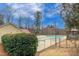 Community pool with a lush green hedge and pool house in a wooded setting under a bright sky at 9005 River Estates Dr, Knightdale, NC 27545