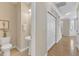 This bright powder room includes a pedestal sink, toilet, and adjacent closet and hardwood floors at 9005 River Estates Dr, Knightdale, NC 27545