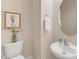 The powder room features a pedestal sink, toilet, decorative artwork, and a round beveled mirror at 9005 River Estates Dr, Knightdale, NC 27545