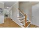 Staircase and foyer featuring hardwood floors, white trim, and a coat closet at 9005 River Estates Dr, Knightdale, NC 27545