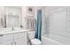 Bright bathroom featuring white cabinets, gray towels, and a blue shower curtain for a clean and fresh space at 102 Red Maple St, Sanford, NC 27332