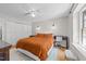 Well-lit bedroom featuring a bed with an orange comforter, modern lighting, and wood floors at 1020 Randolph Ct, Cary, NC 27511