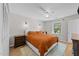 Spacious bedroom featuring a bed with an orange comforter, modern lighting, and wood floors at 1020 Randolph Ct, Cary, NC 27511