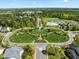 An aerial view of a neighborhood with manicured lawns, tennis courts, and a community pool at 1033 Laredo Ln, Durham, NC 27703